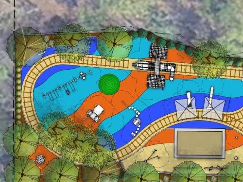 Color site plan of the Crossbuck Play Space: curving rail-track paths, swings, a play structure, shade sails and a lawn