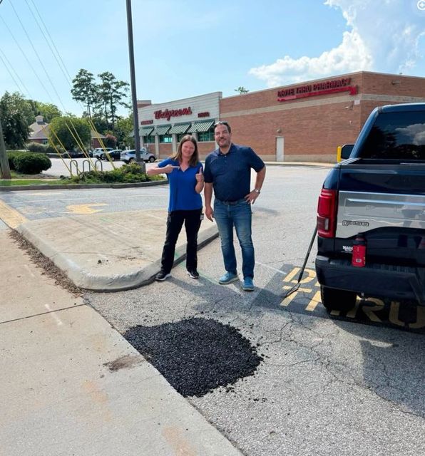 Gabriel beside a freshly filled pothole outside Walgreens